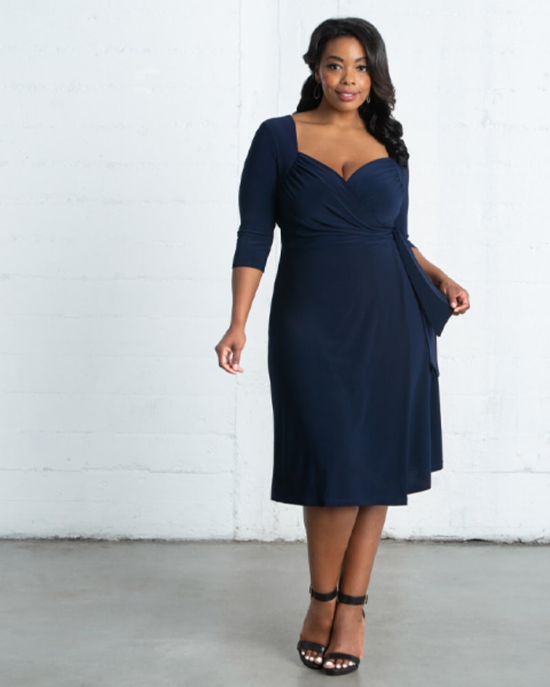Front of a model wearing a size 0X Chrystie Knit Wrap Dress in NAVY BLUE by Kiyonna. | dia_product_style_image_id:274067